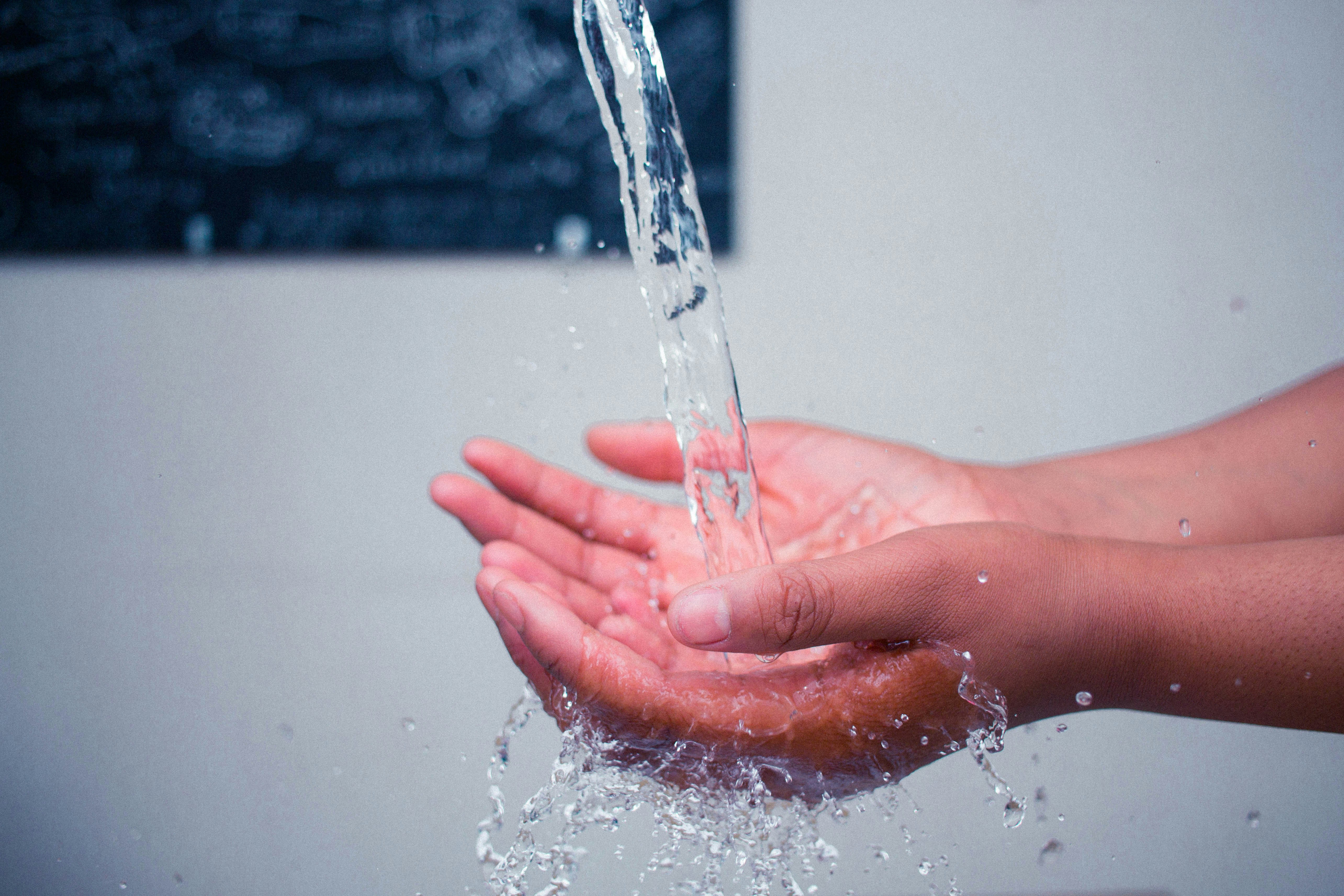 Hands cupped receiving water stream
